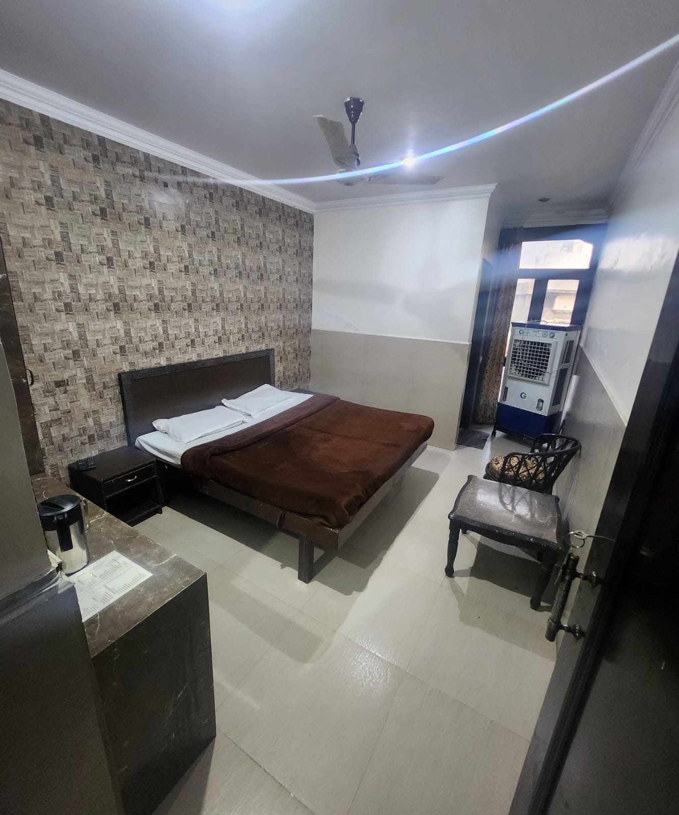 Basic Non A/C Room — double bed and a textured feature wall