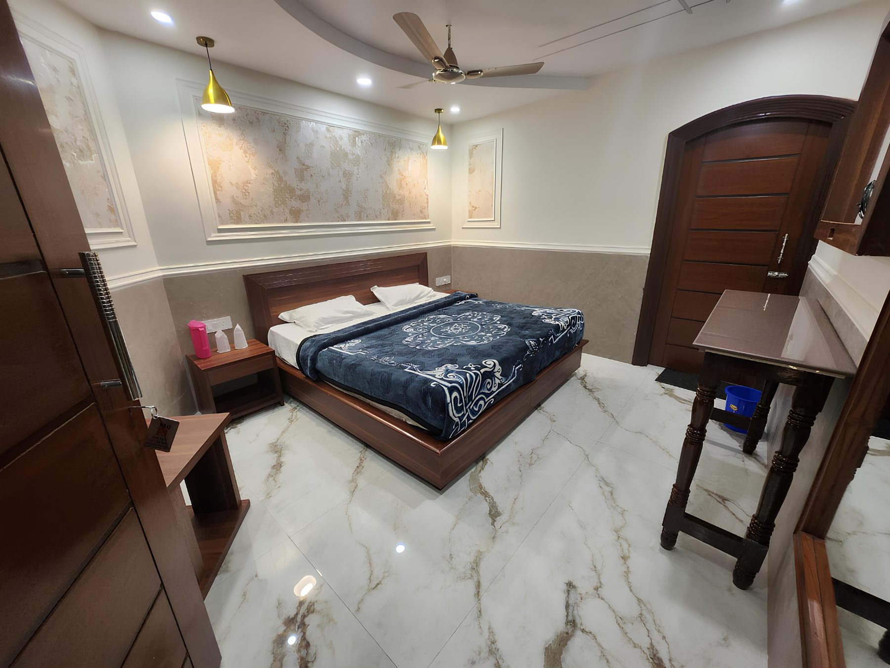 Executive Room at Hotel Uttam Heritage — double bed against a panelled feature wall, polished marble floor