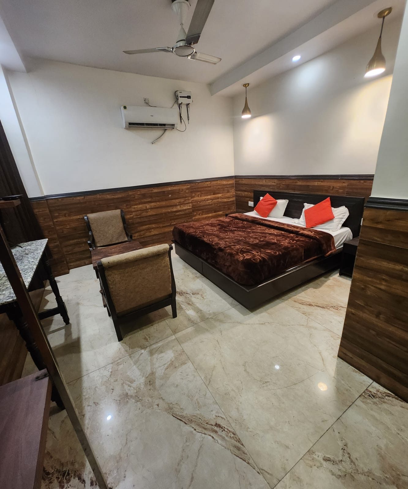 An Executive Room with walnut panelling, an armchair and a double bed