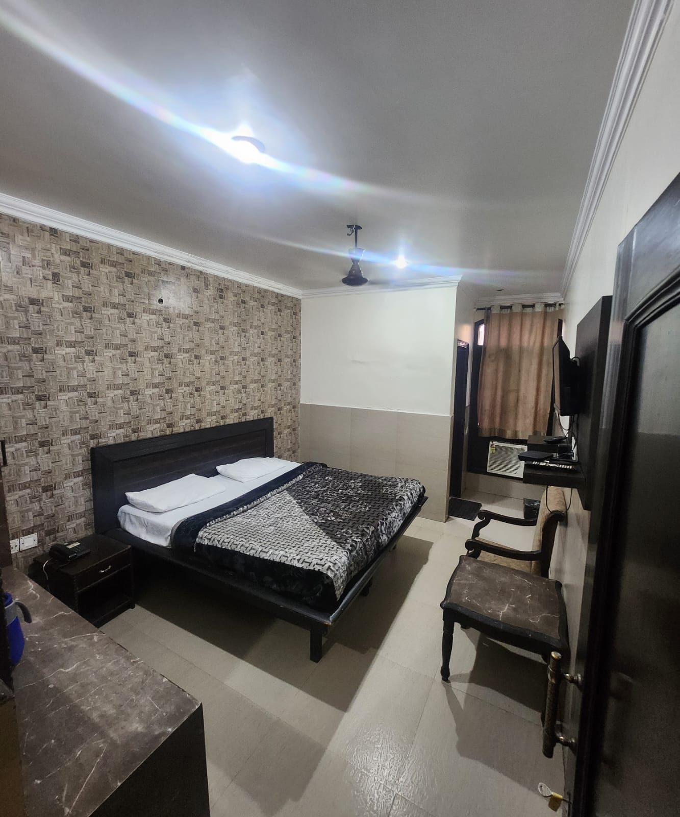 Standard A/C Room at Hotel Uttam Heritage — double bed with a patterned feature wall